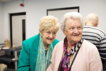 Two elderly women having a giggle together