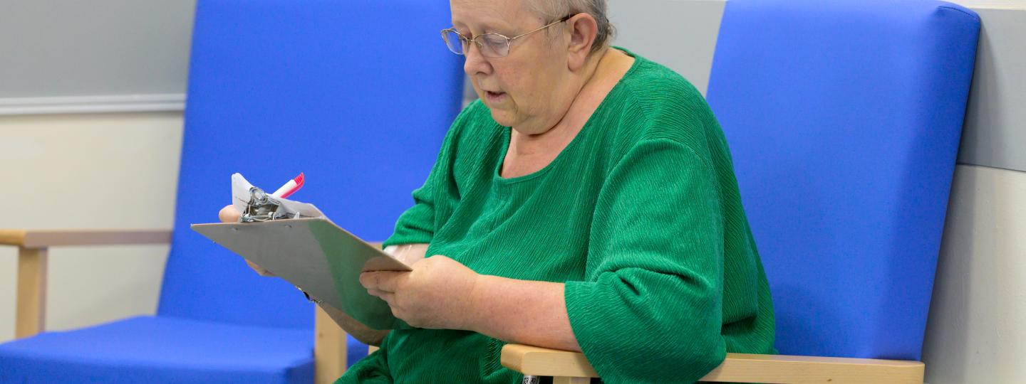 woman completing a survey on a clipboard